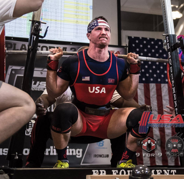 John Haack in Nike weightlifting shoes and an SBD singlet, belt, wrist wraps and knee sleeves